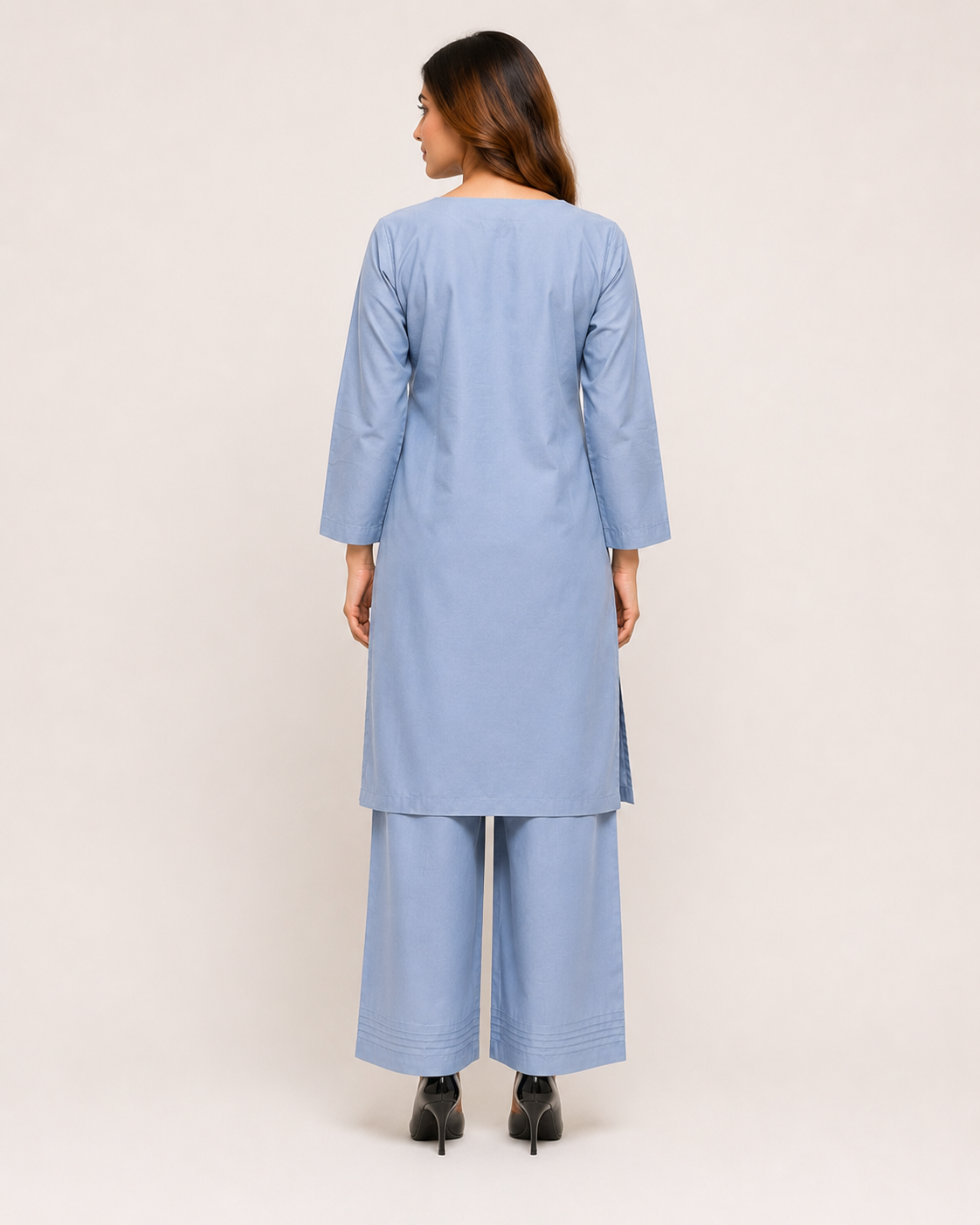 A woman shown from the back wearing a light blue kurta and matching wide-leg pants against a plain light beige studio background.